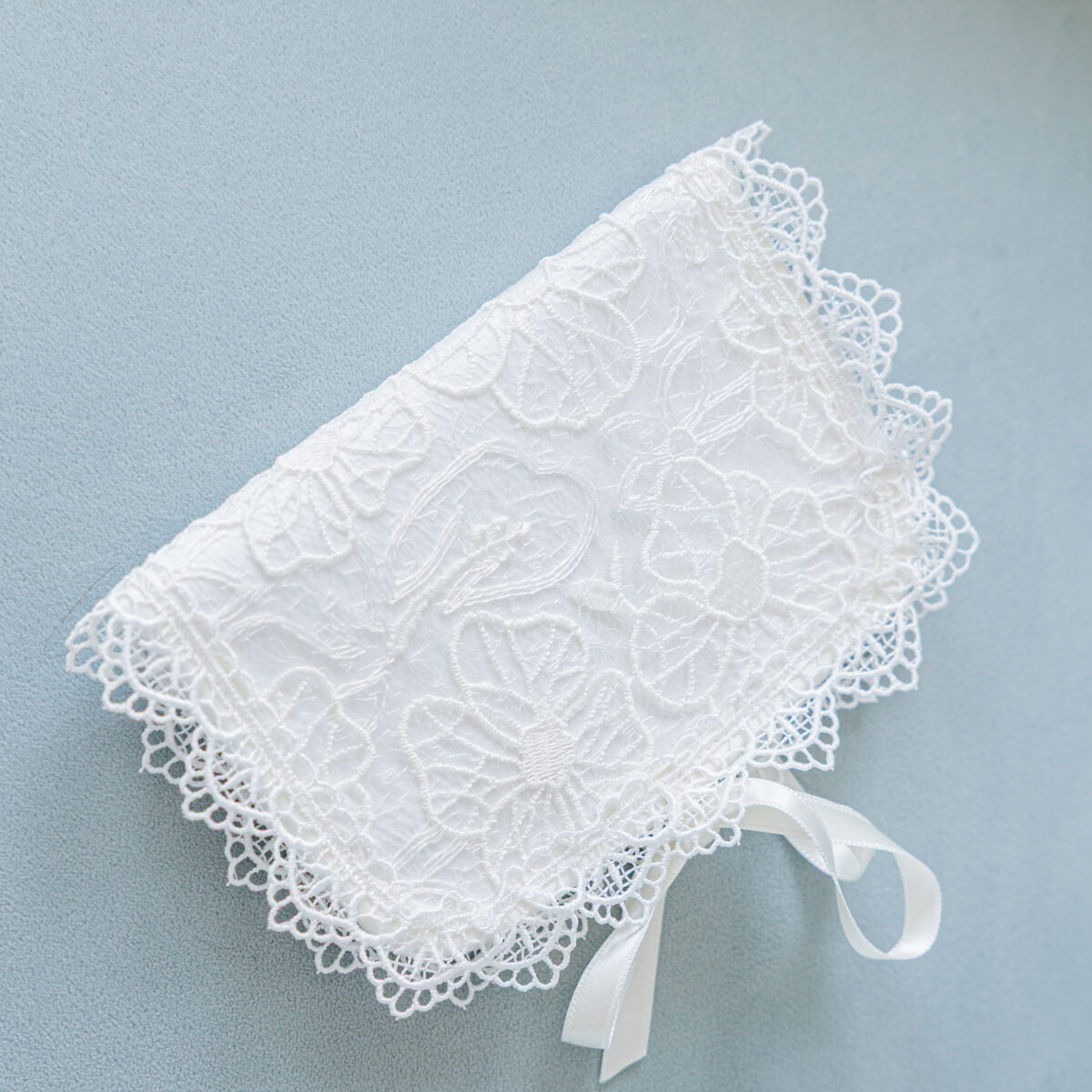 Baptism Keepsake Box for First Curl with a ribbon on a light blue background