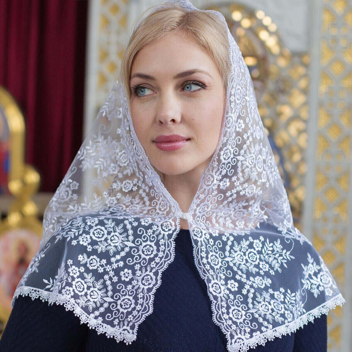 Woman wearing a Catholic Church Mantilla with a blurred decorative background