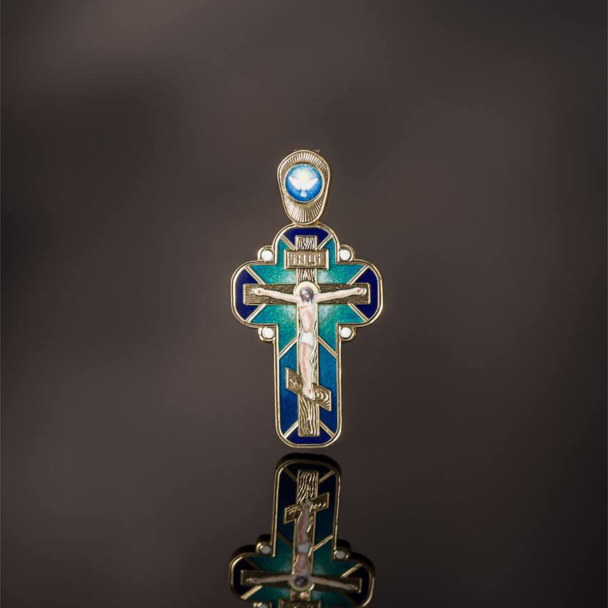 Baptism cross with blue and gold elements on a reflective surface