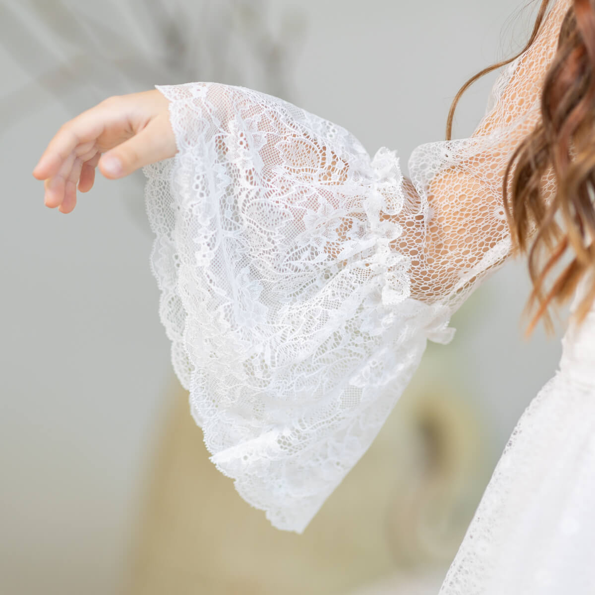 Close-up of a person wearing a Elegant cotton communion dress with a blurred background