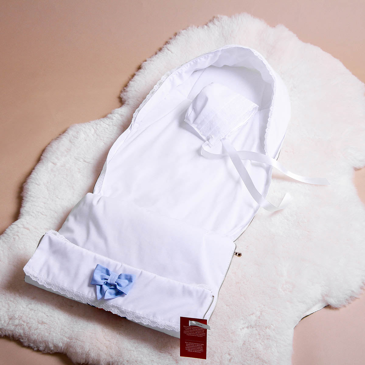 Newborn Sleep Sack for Summer with a blue bow on a beige surface