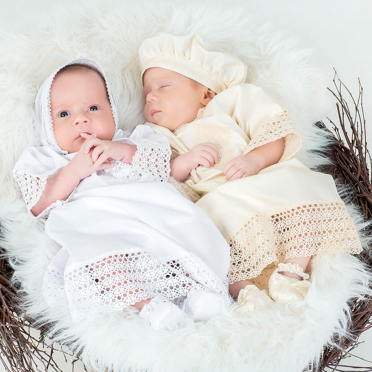Two babies in Baptism Gown  lying on a fluffy surface