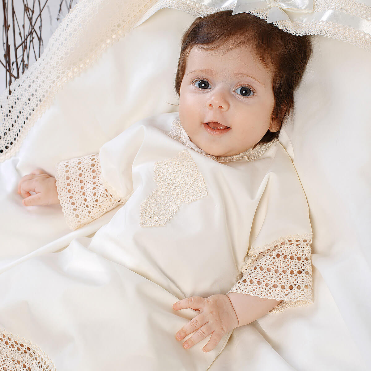 Baby in a Baptism Gown lying on a white blanket