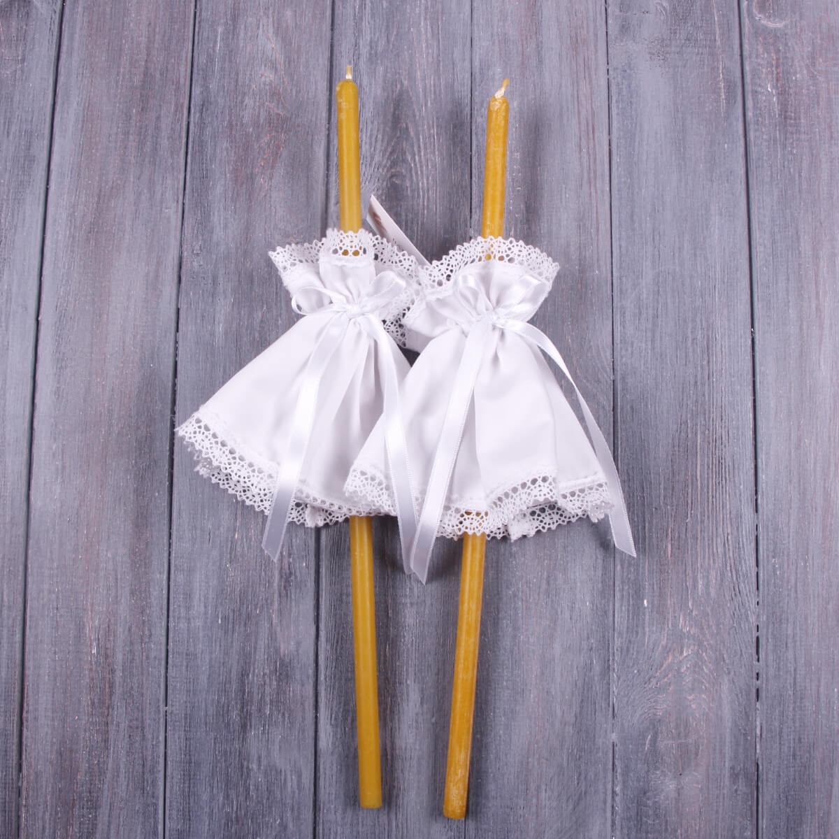 Two yellow candles with  Fabric Candle Wraps on a wooden background