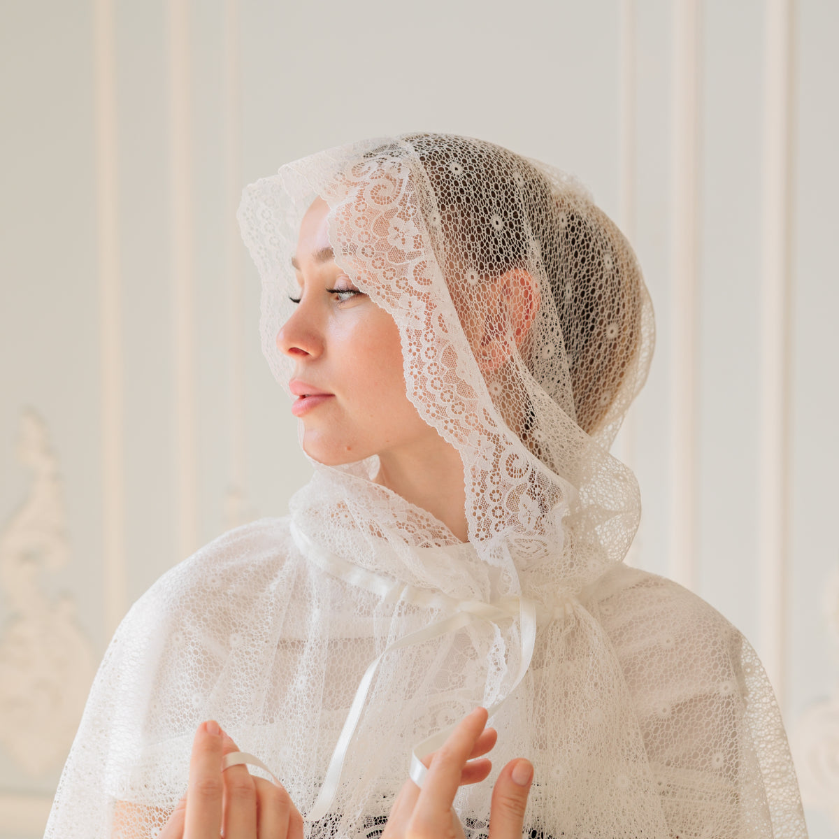 Woman wearing a  Catholic Church Mantilla with a neutral background