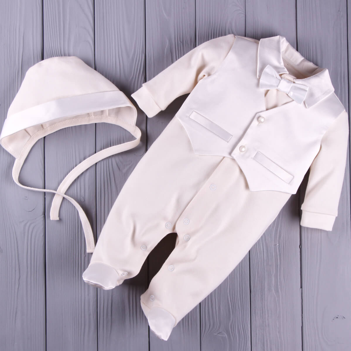 Newborn Coming Home Romper with hat on a wooden surface