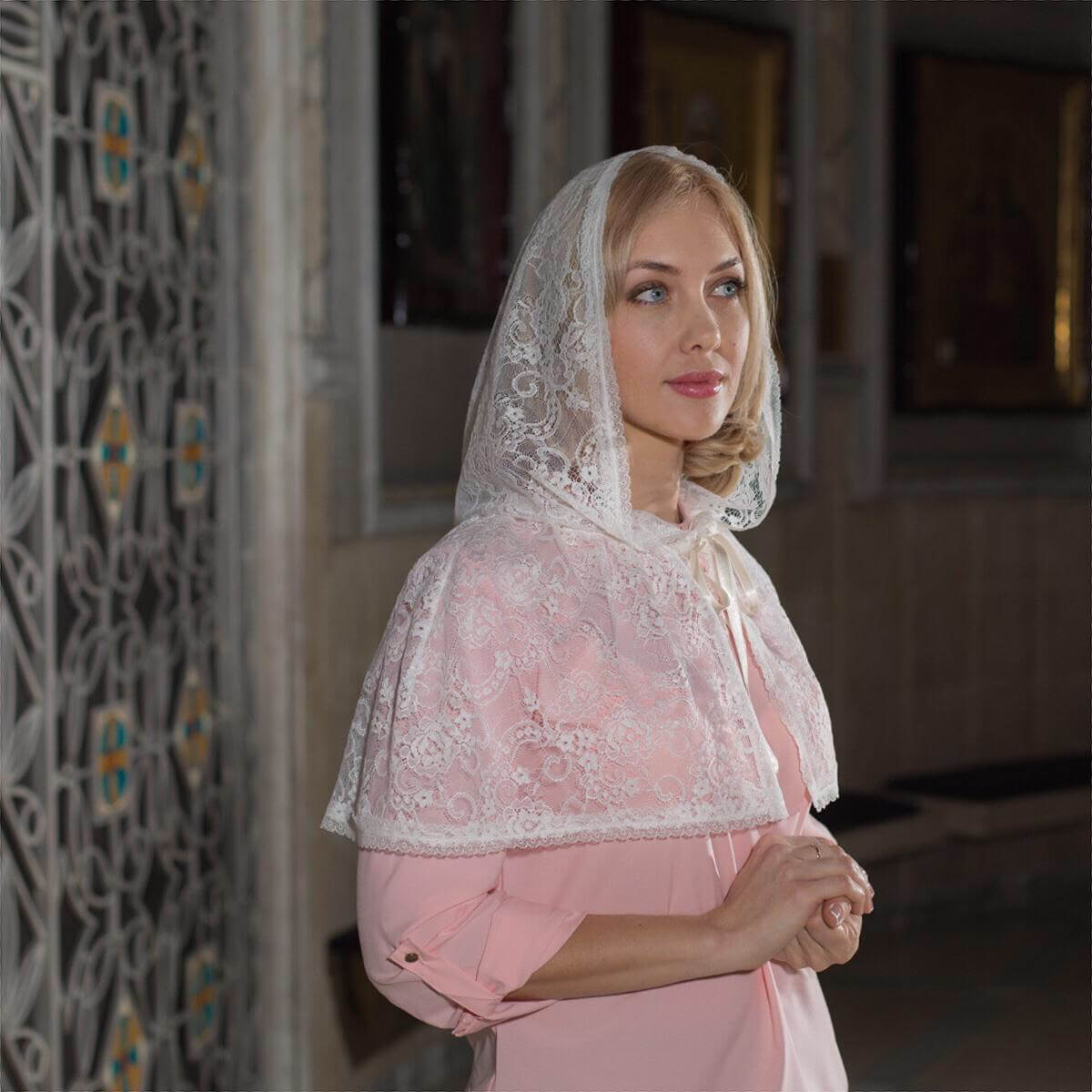 Woman wearing a pink dress and  Caped Lace Veil indoors