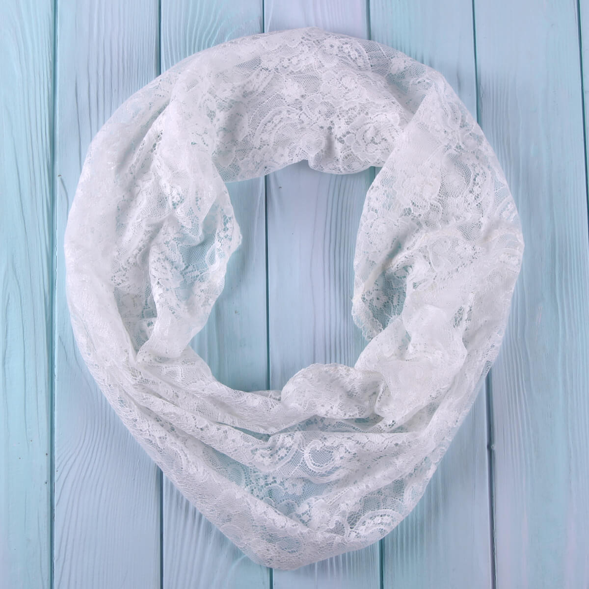 White Catholic Infinity Veil on a light blue wooden background