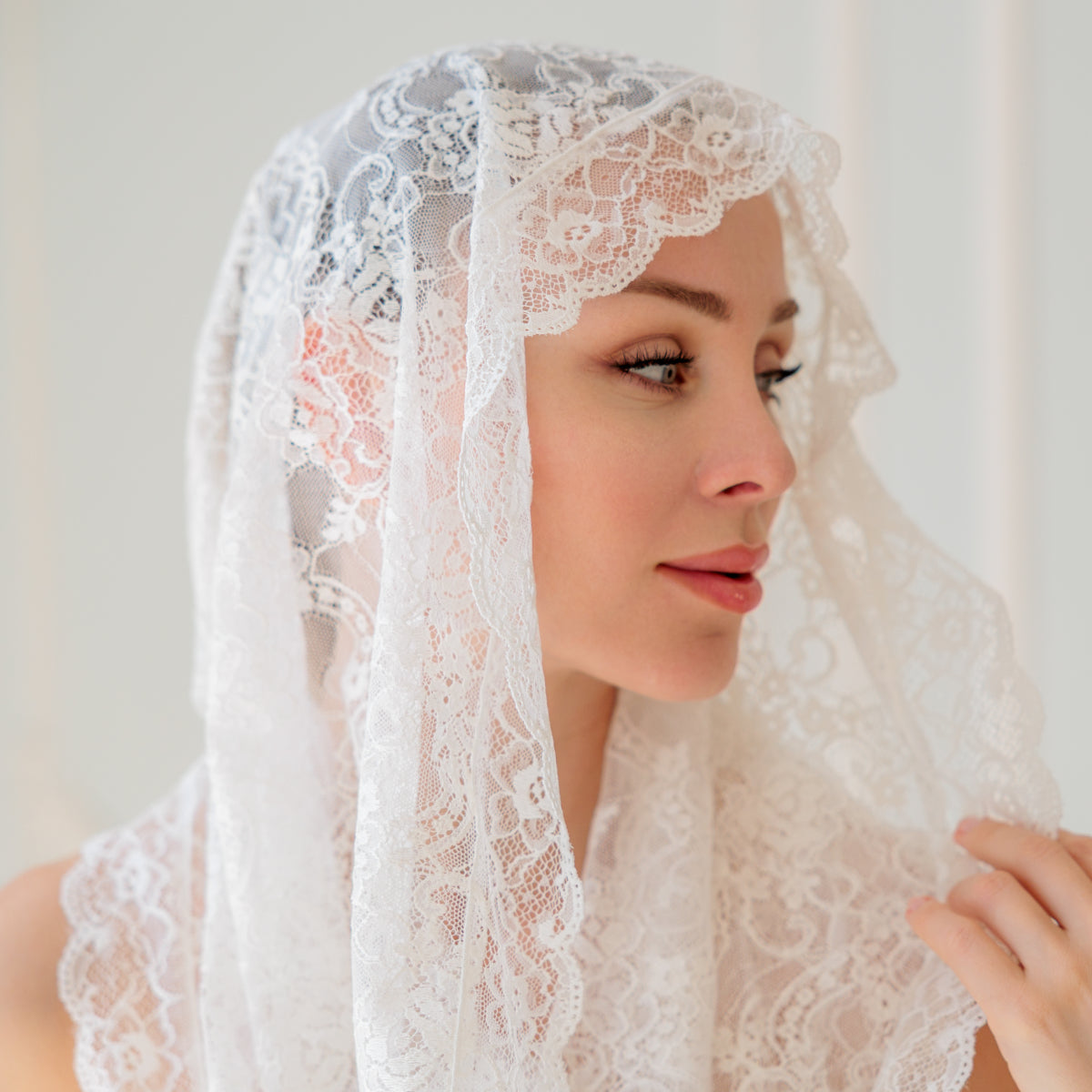 Woman wearing a  Infinity Veil against a plain background