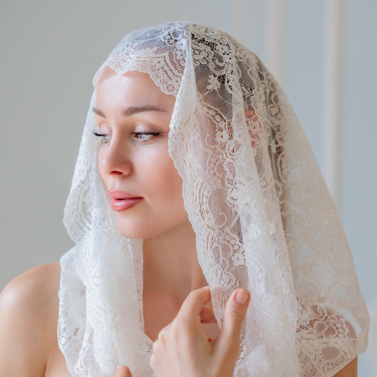 Woman wearing a  Infinity Veil against a plain background