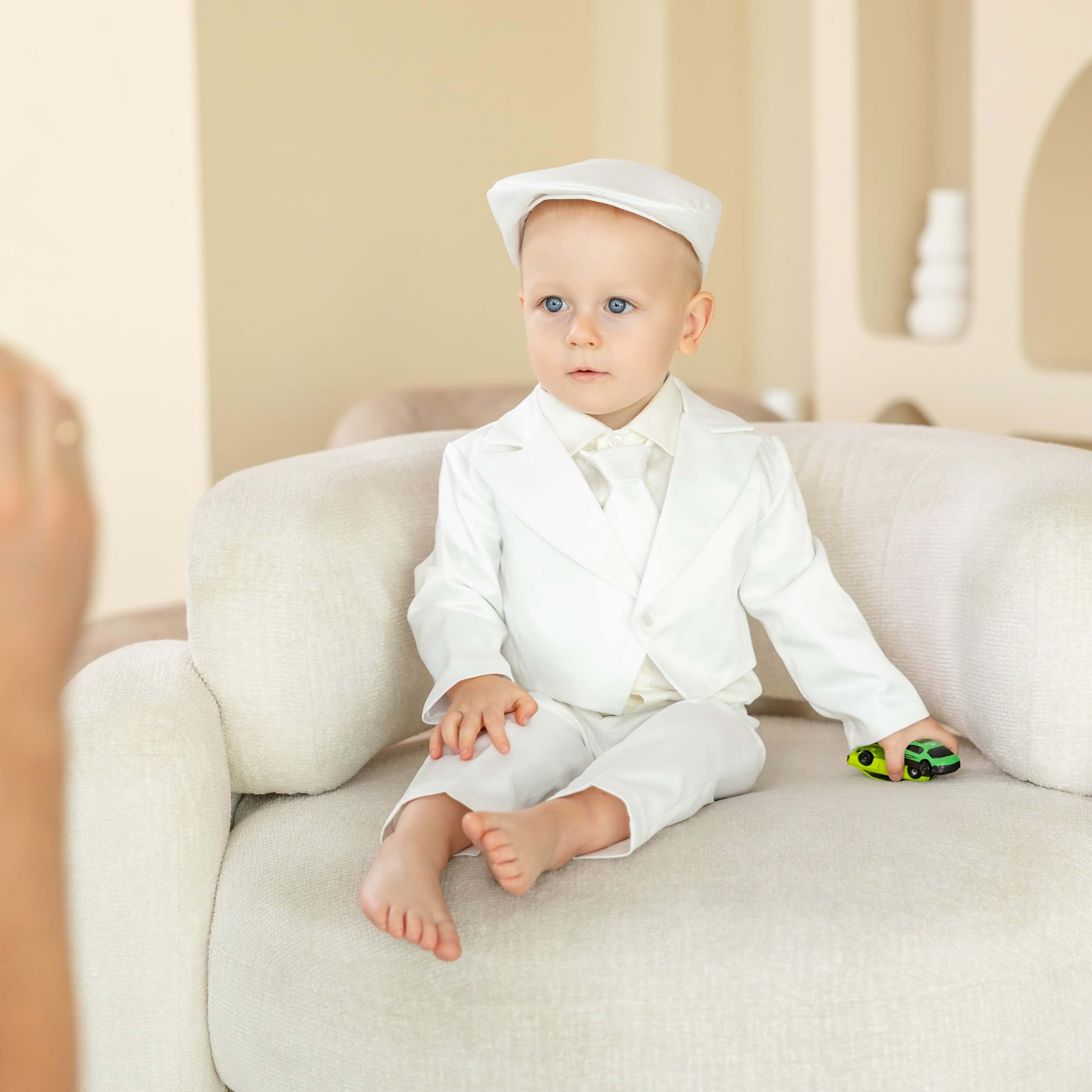 Baby in a Baptism Suit for Baby Boys sitting on a couch