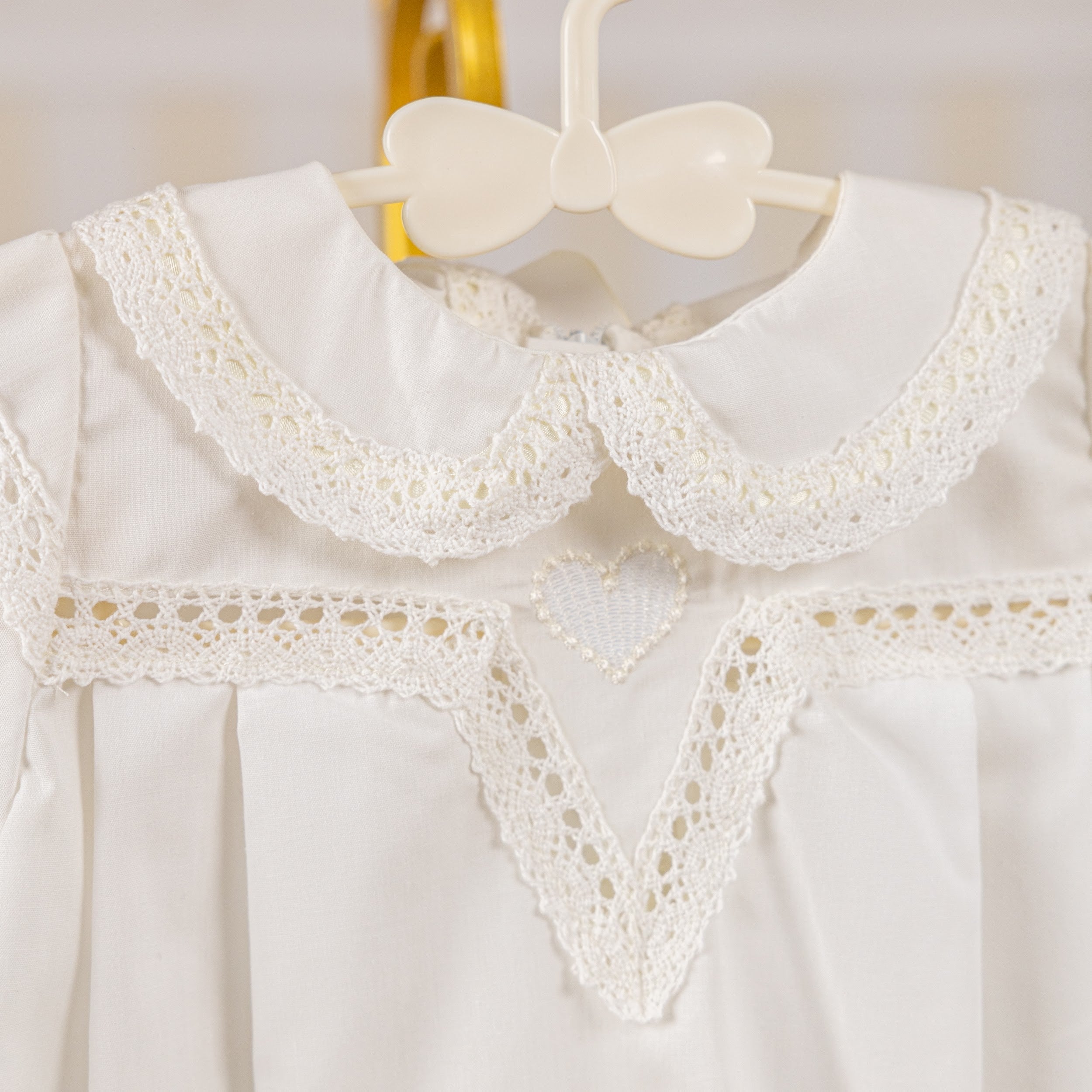 Girls Baptism Gown with lace details on a hanger