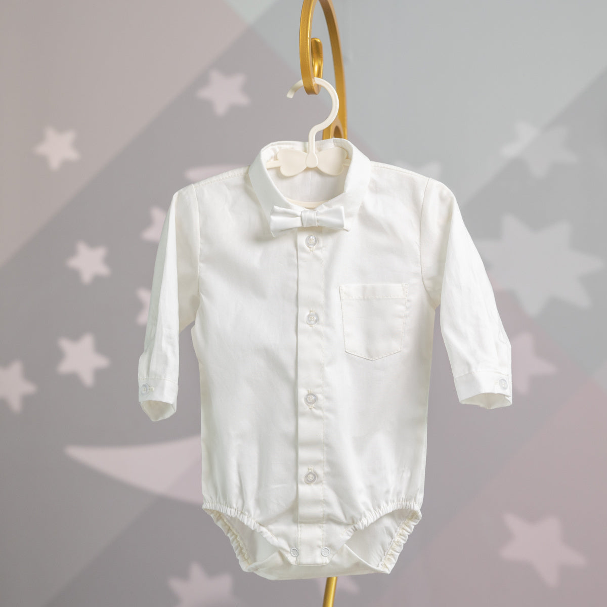 Baby Boy Baptism Suit – with bow tie on a hanger against a star-patterned background