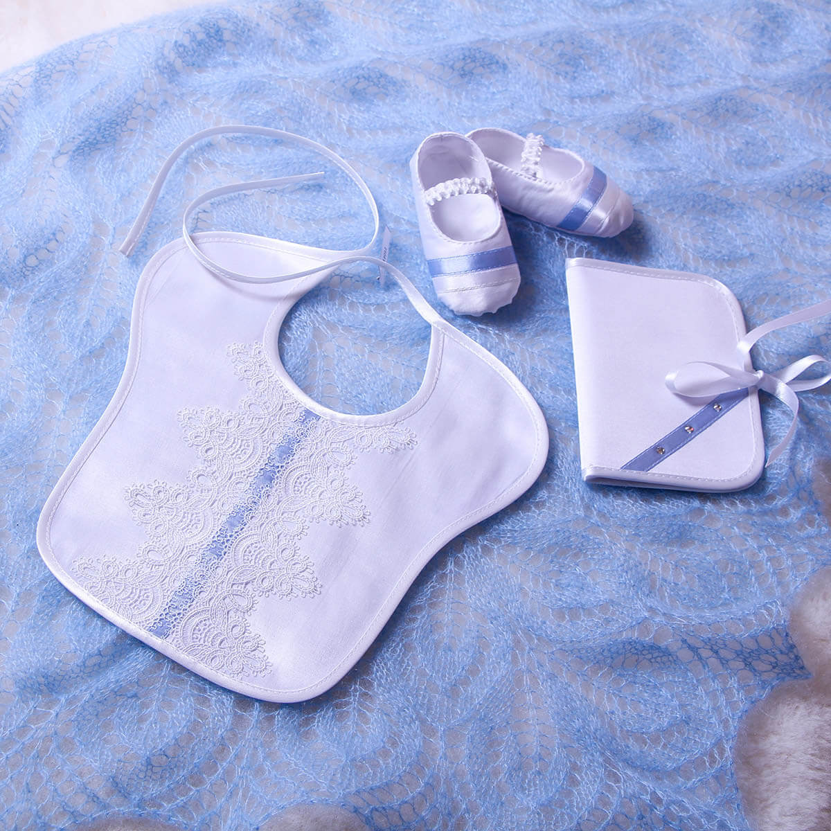 Baptism Bib , shoes, and blanket with blue and white design on a matching background