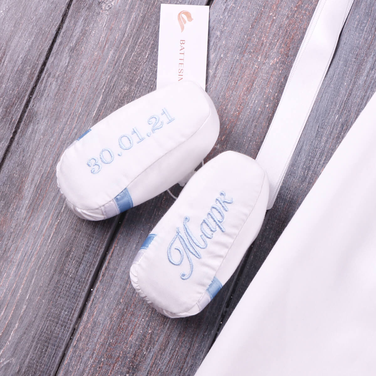  Christening Booties with blue text on a wooden surface