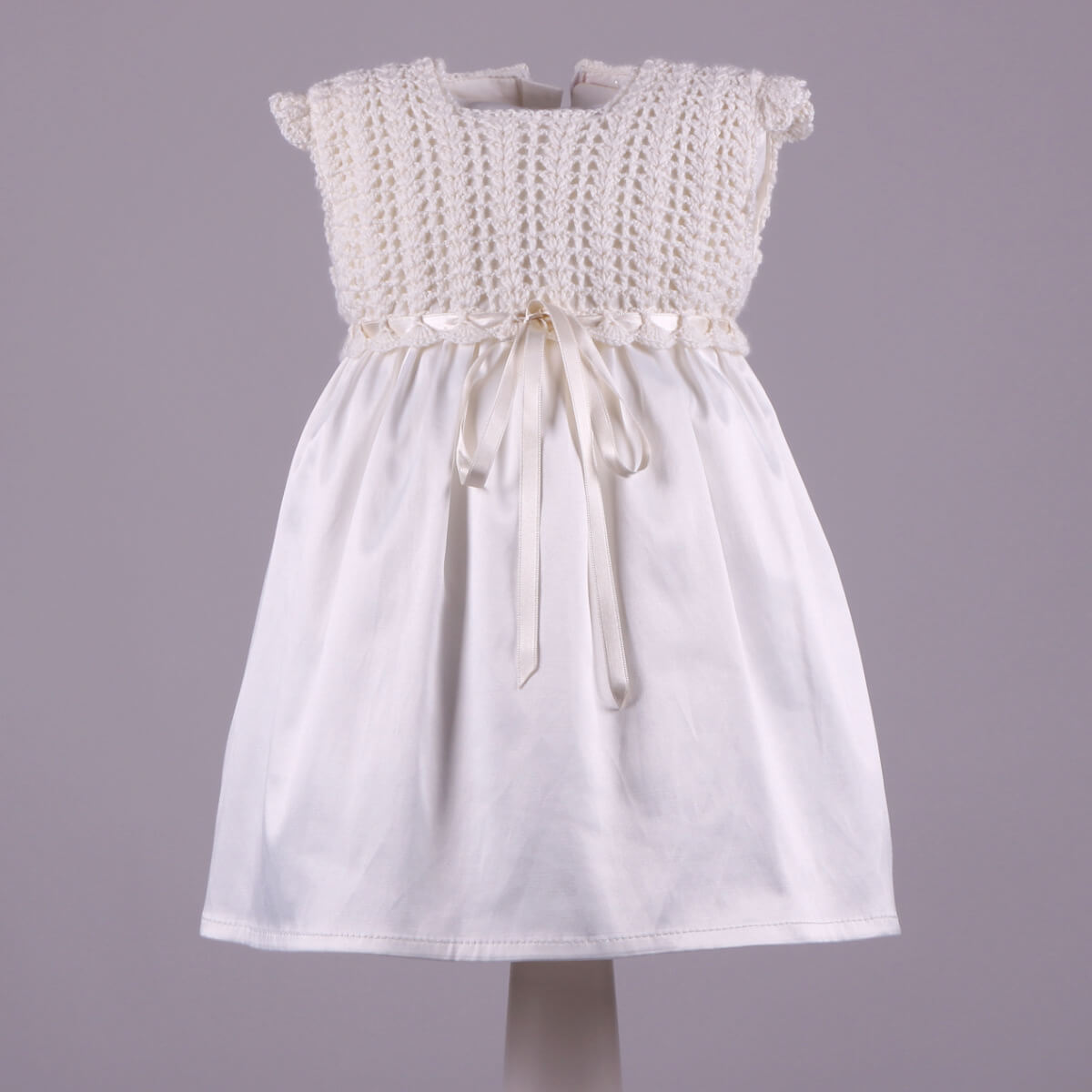Crochet Christening Dress with a textured top on a gray background