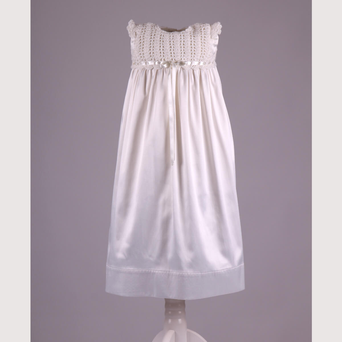 Christening Gown for Girls with lace top on a mannequin against a gray background