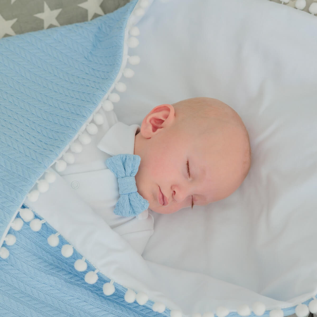 Newborn baby sleeping on a Coming Home Blanket with a bow.