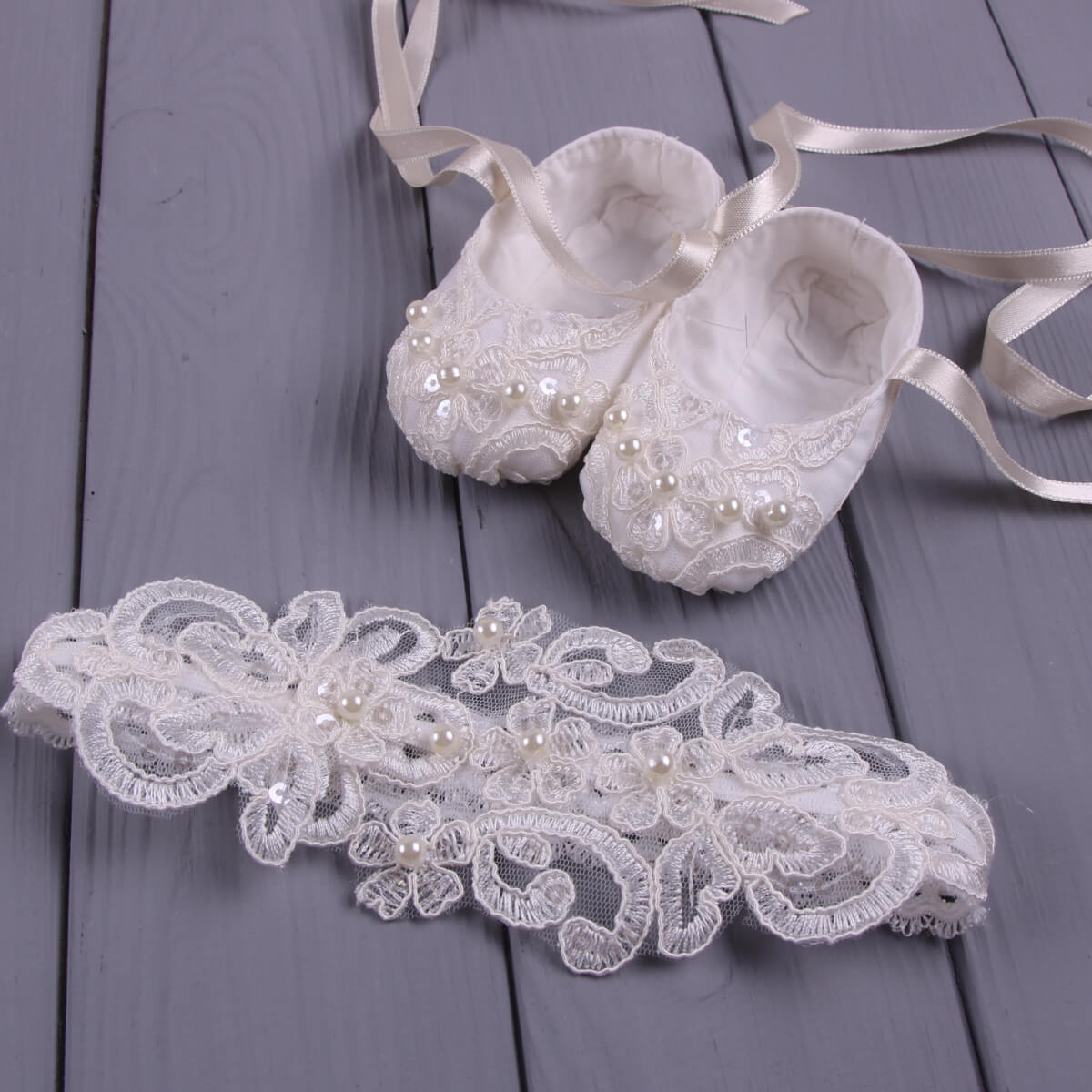  Baby headband with lace and pearls sitting on a wooden surface
