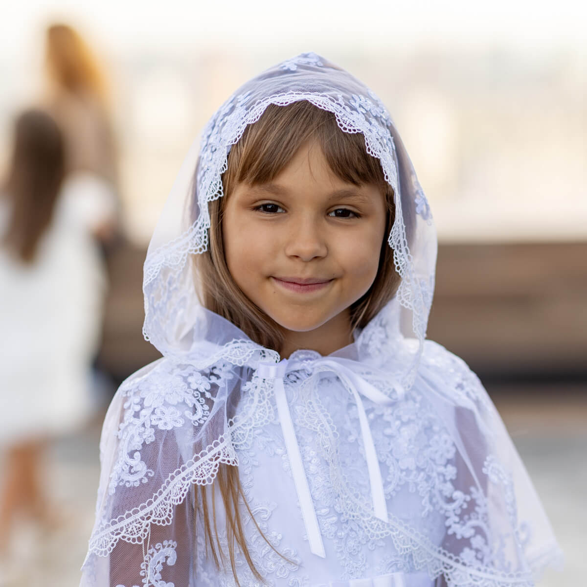 Young girl wearing a Holy Communion Mantilla with a blurred background