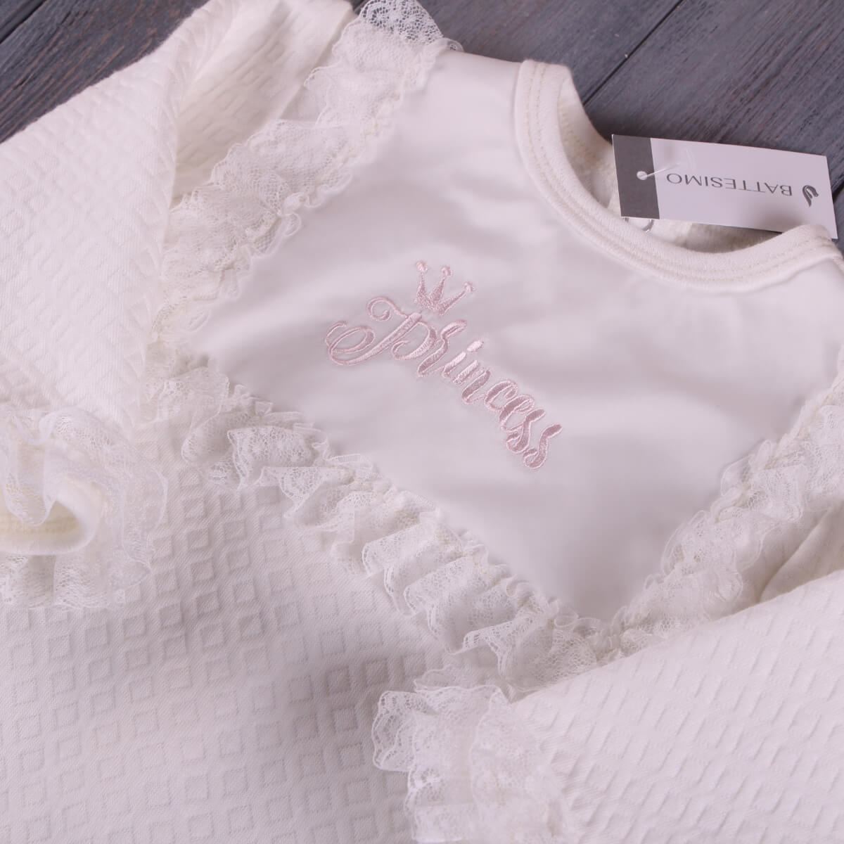 Baptism Romper Set  with lace details and 'Princess' embroidery on a wooden surface.