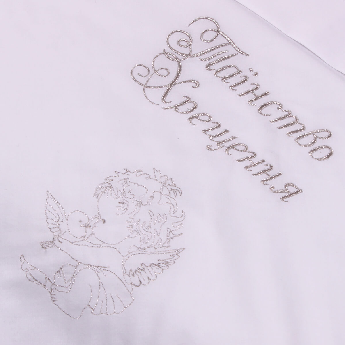 Embroidered angel design and text on a white baptism blanket
