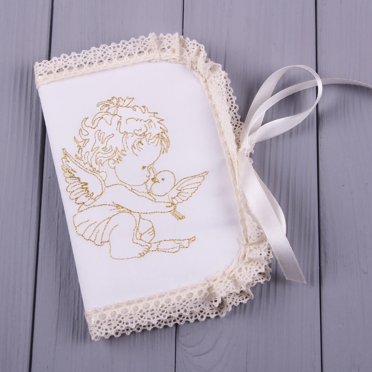 Decorative white fabric with gold angel design on a wooden surface