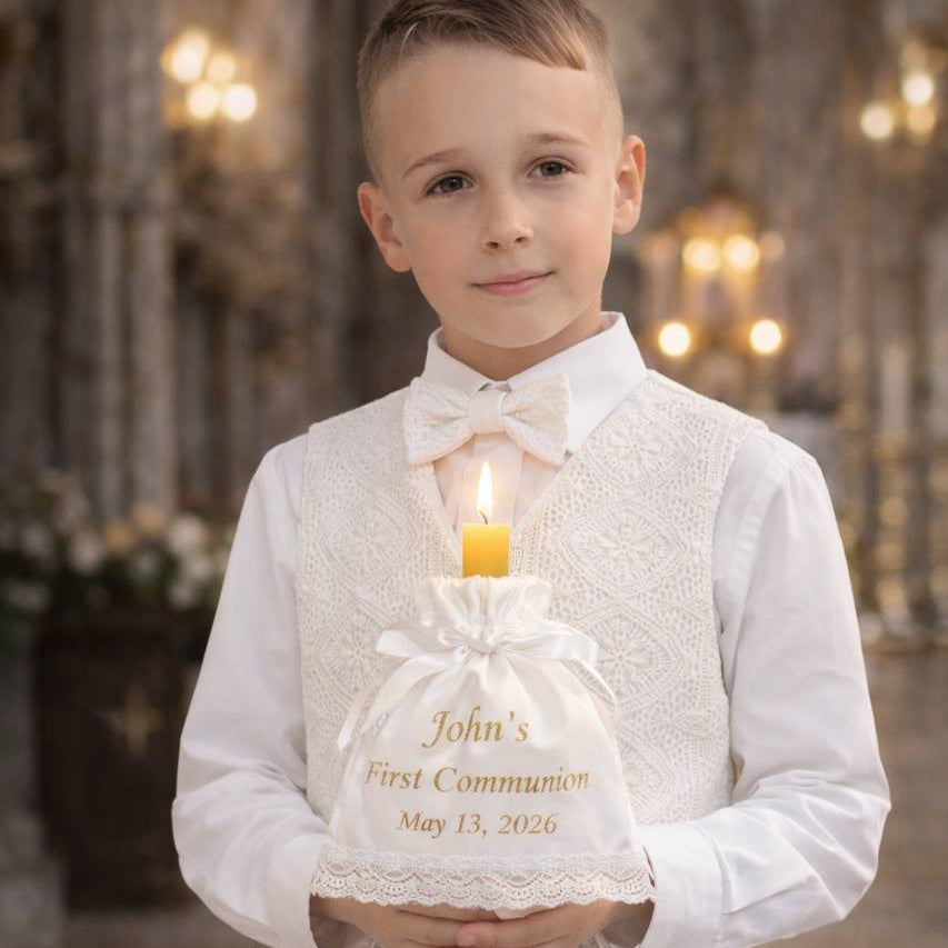 Young boy in formal attire holding a First Communion candle in an ornate setting.