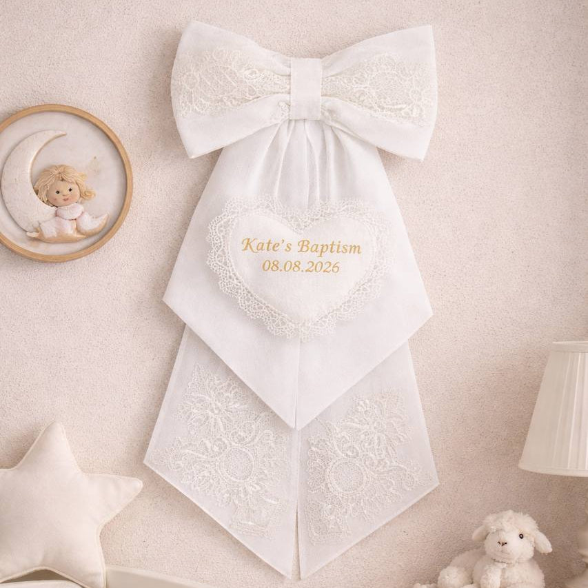 Personalized Baptism Keepsake Bow with embroidered text on a wall above a crib in a nursery.