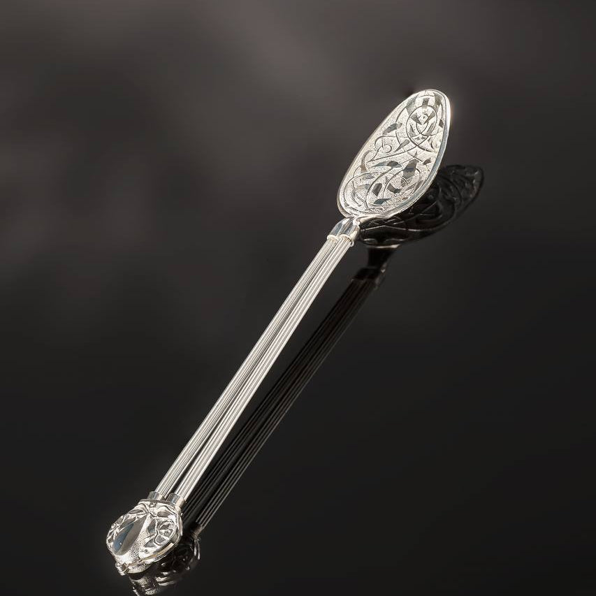 Decorative silver spoon on a dark background