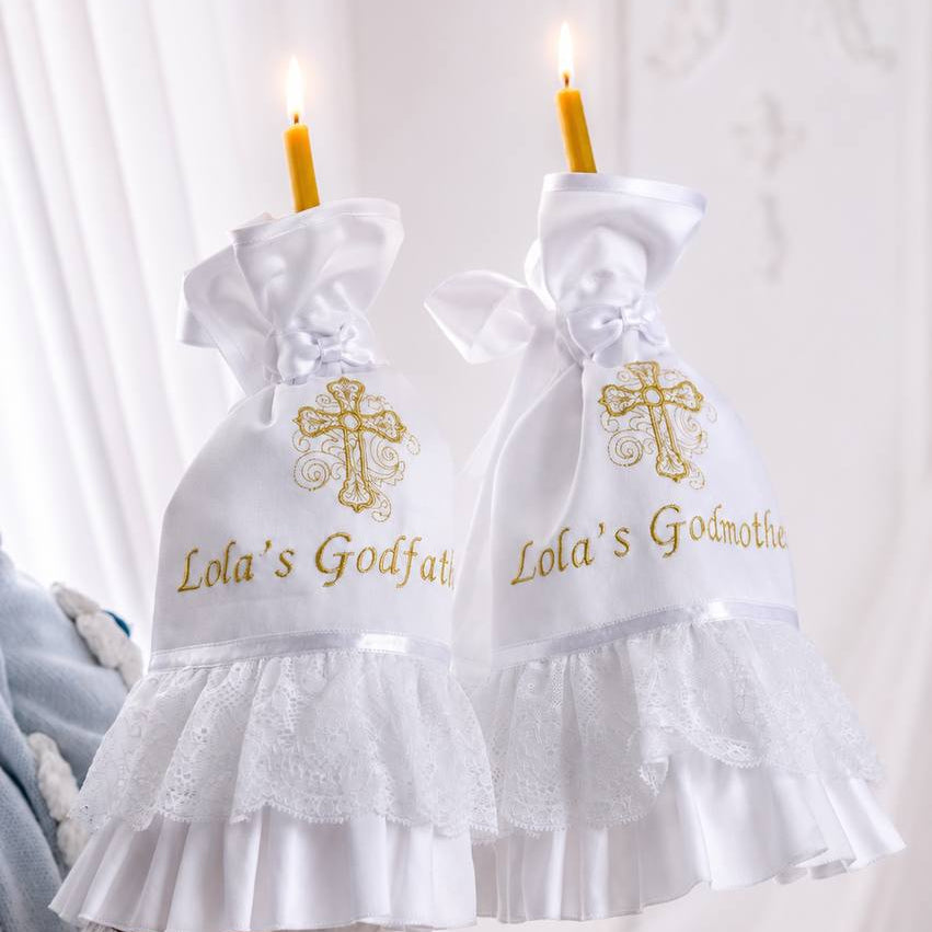 White godmother and godfather candle wraps with ruffles and crosses on a white background. 