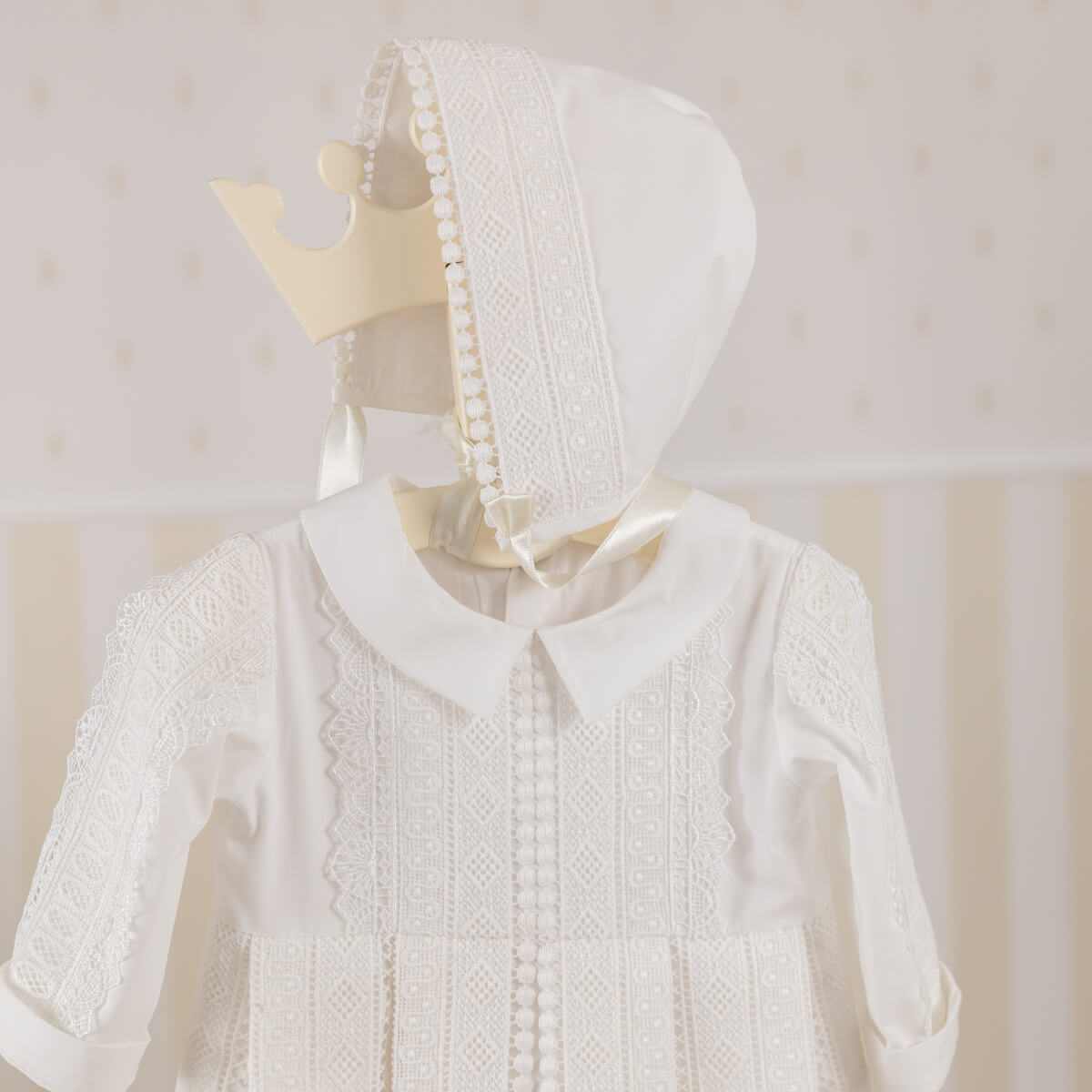 Christening gown with matching bonnet on a mannequin 