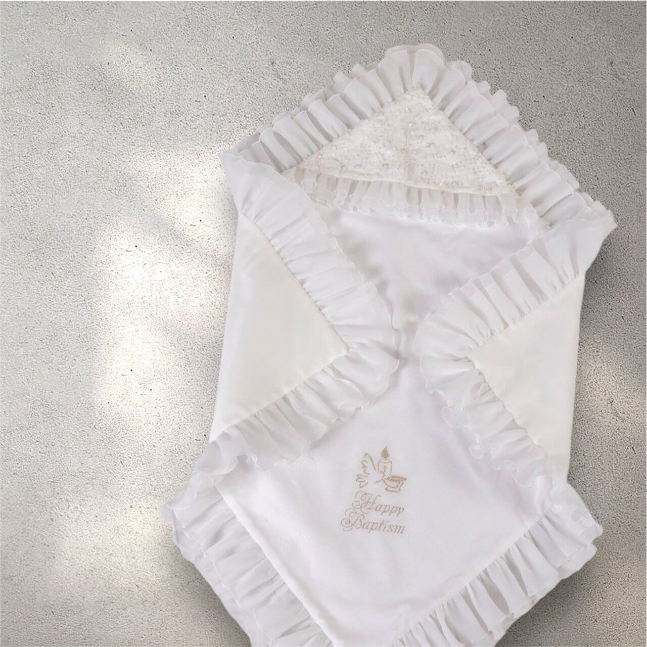 White baby blanket with ruffled edges and 'Happy Baptism' embroidery on a gray background