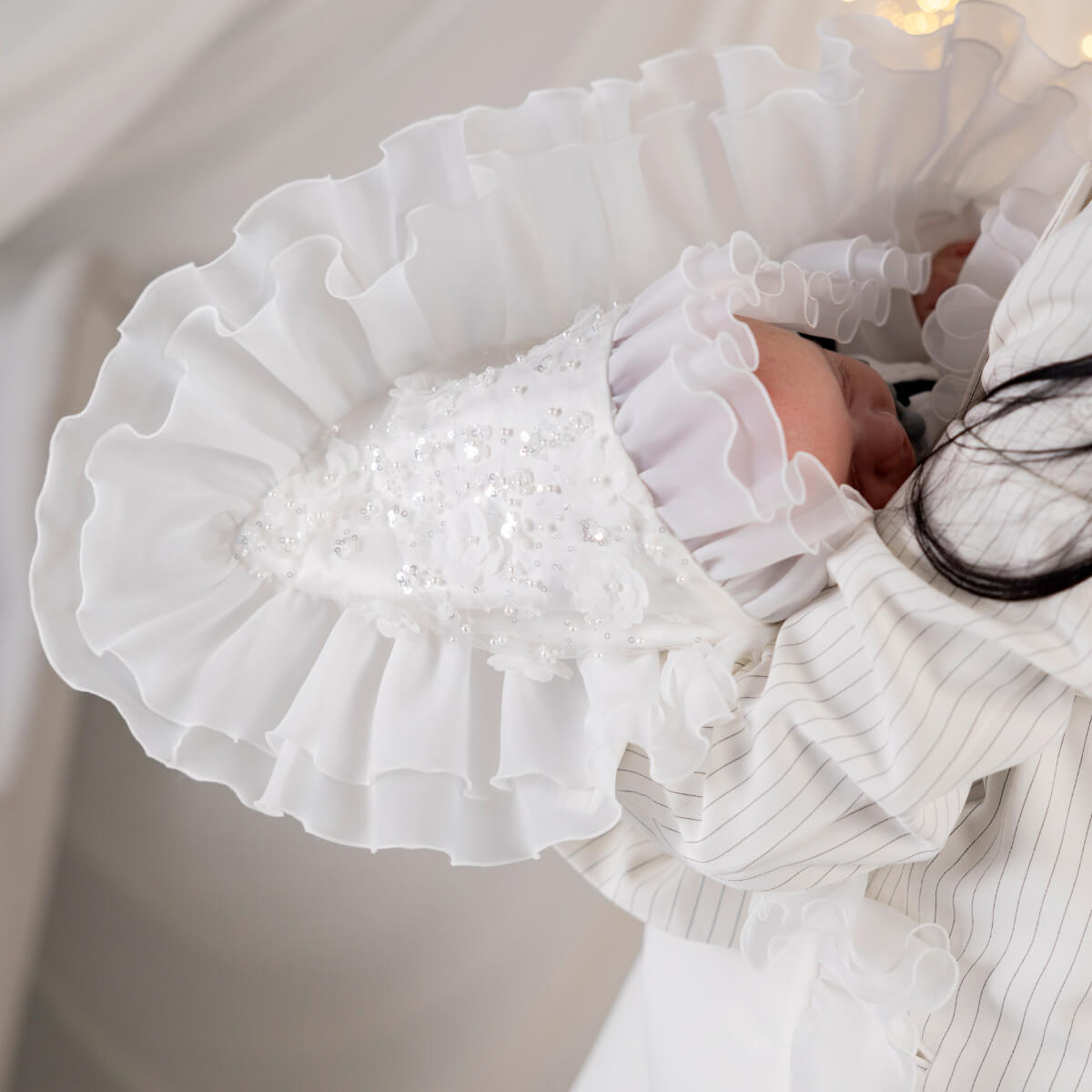 Close-up of a white ruffled luxury blanket for baptism with a blurred background