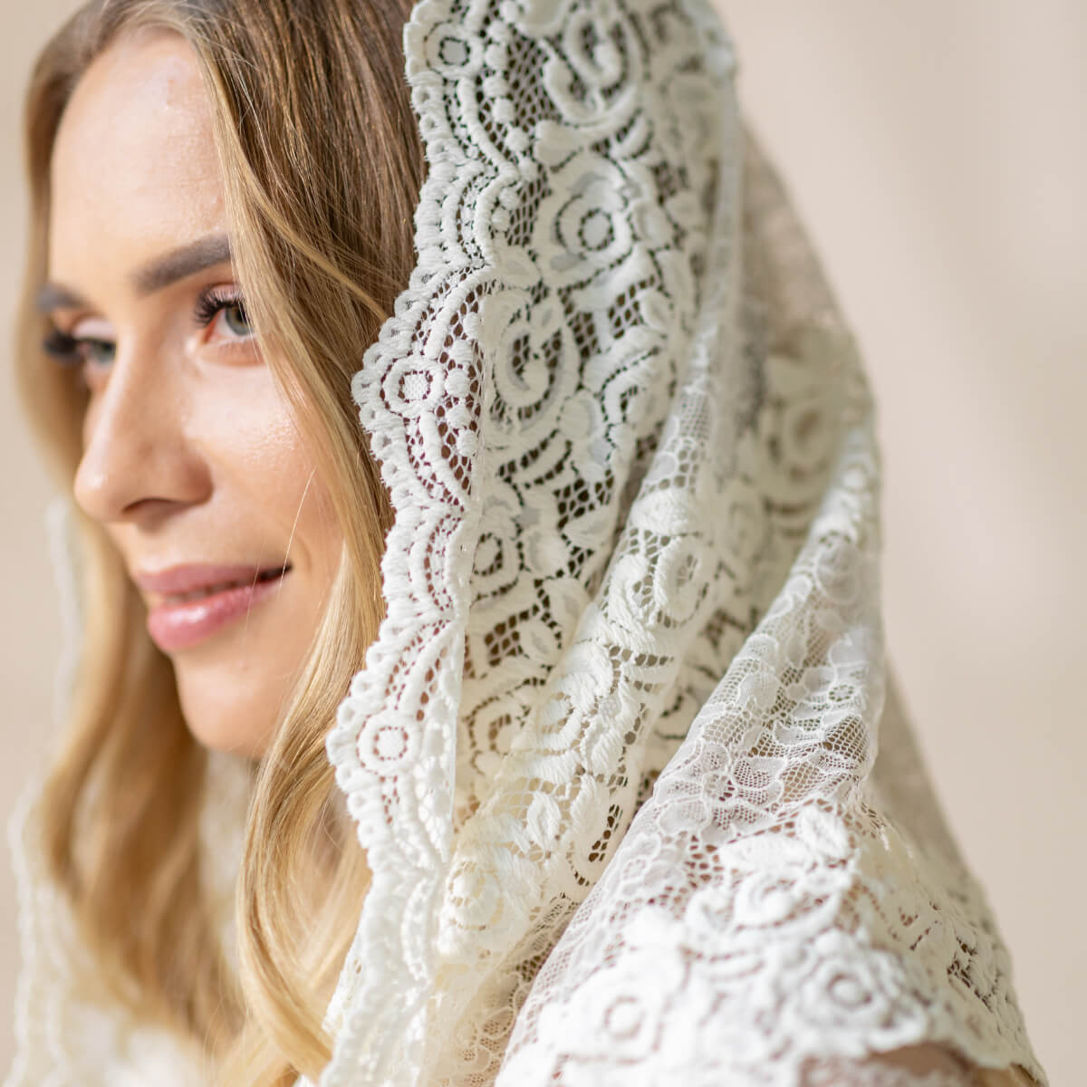 Woman wearing a Catholic Infinity Veil  with a neutral background