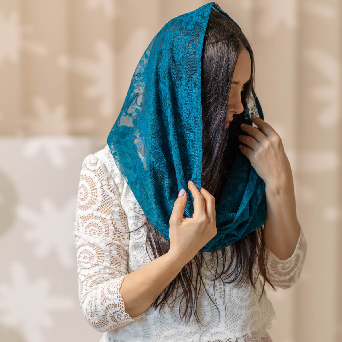 Woman wearing a Catholic Infinity Veil against a beige background