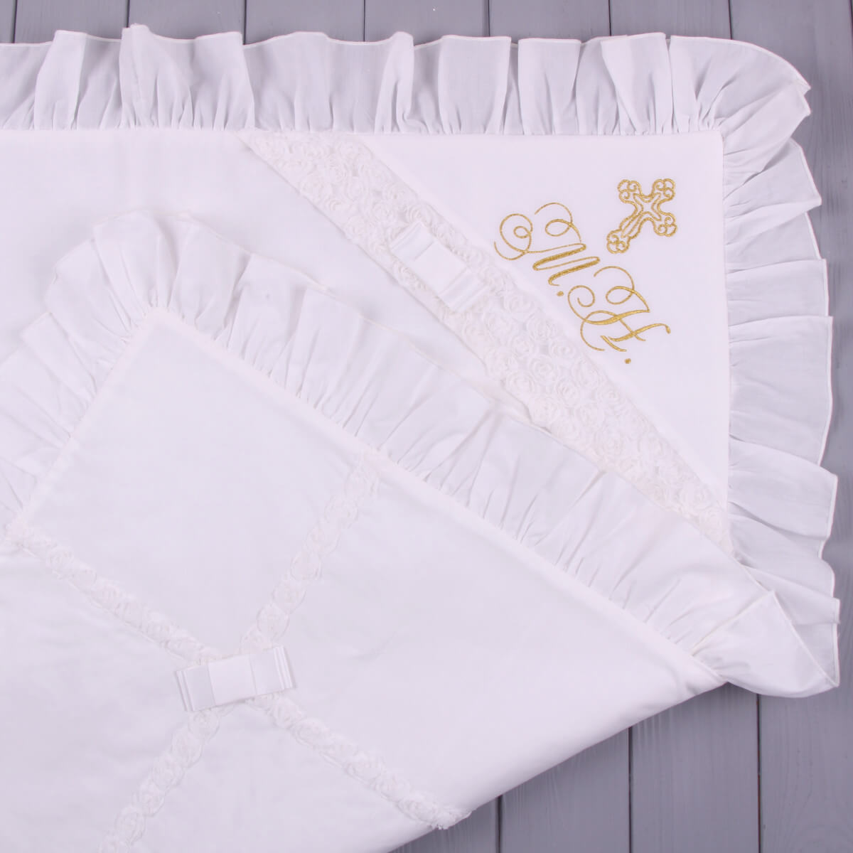White embroidered blanket with gold lettering on a wooden surface