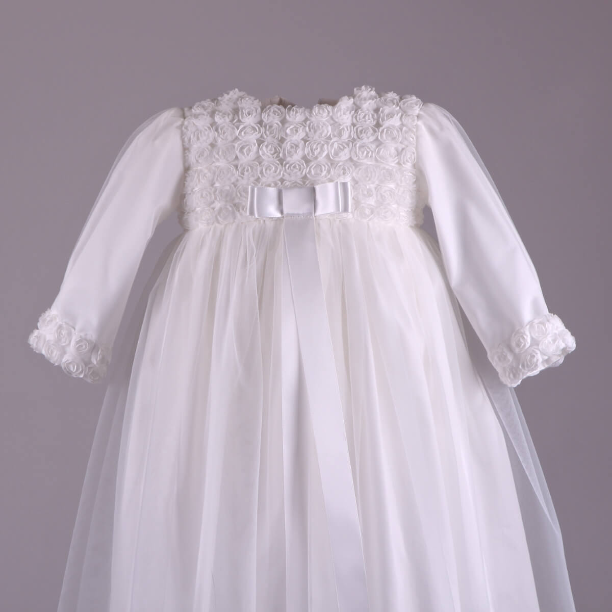 Girls Christening Gown with long sleeves on a gray background