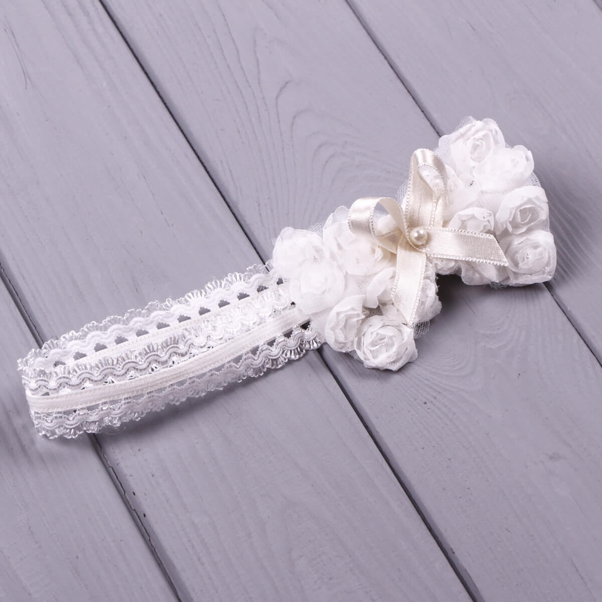 Baby headband with bow  on a gray wooden surface