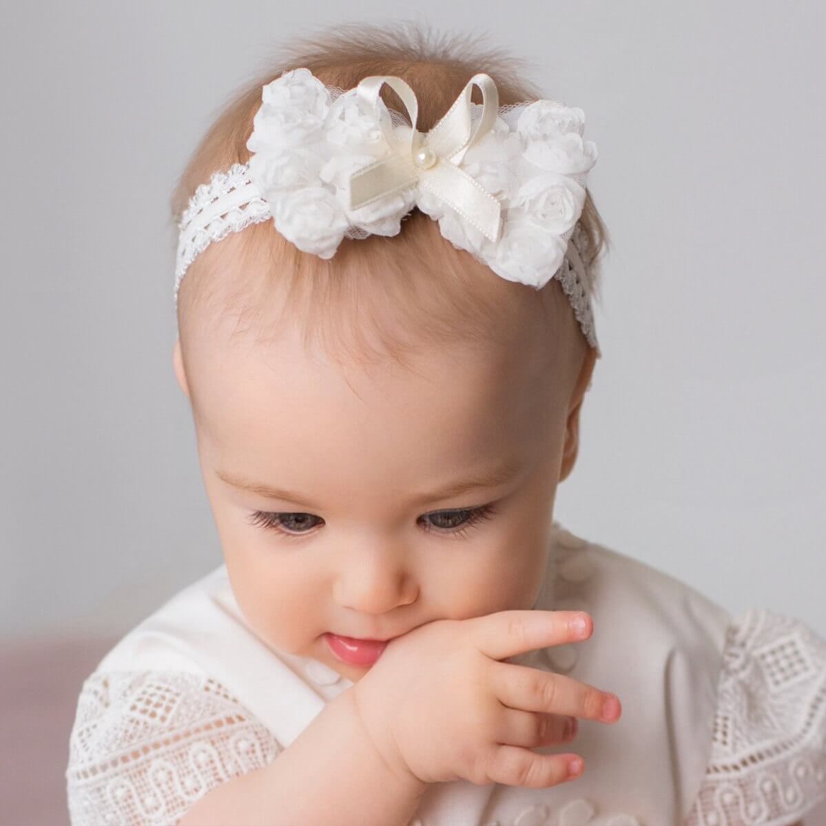 Baby headband with bow , against a plain background