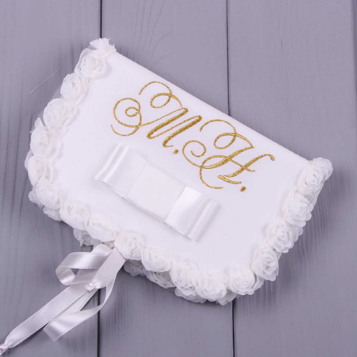 Baby Christening Keepsake Box with gold monogram on a gray wooden surface