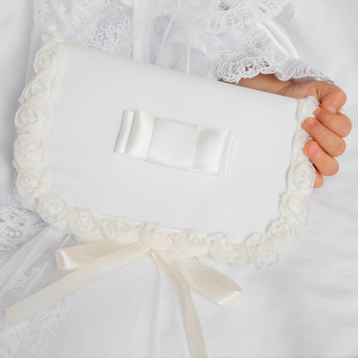 Baby Christening Keepsake Box with lace trim and a bow held by a hand against a white background