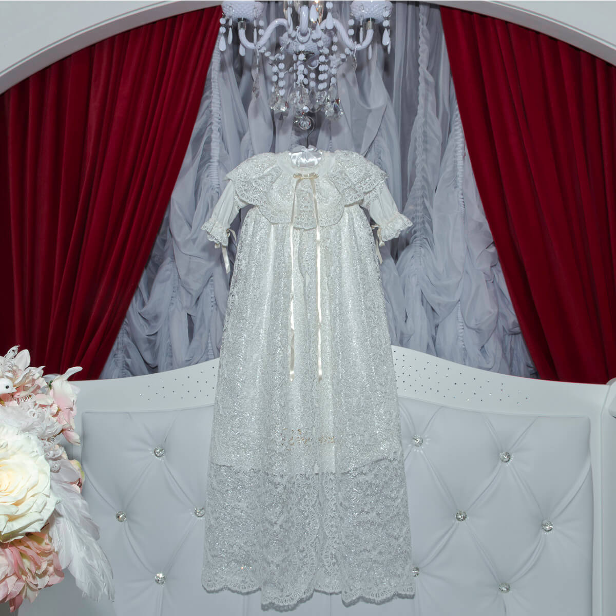 Elegant white lace christening gown on a mannequin 