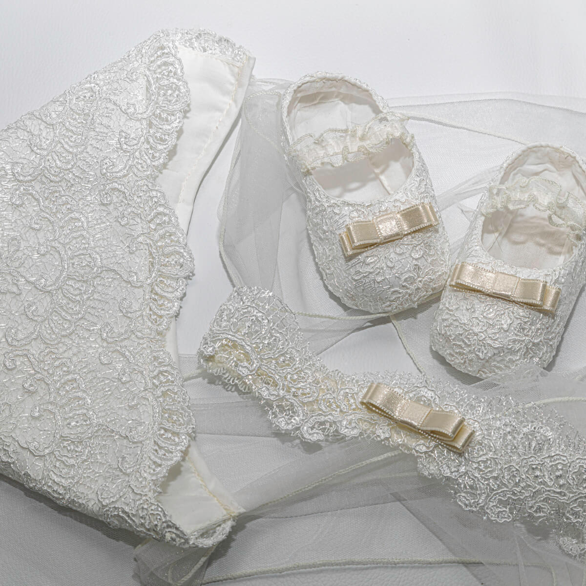 Lace baby shoes with bows on a white background