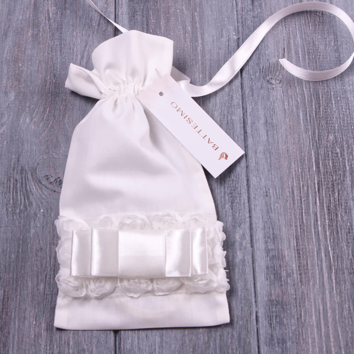 aptism Keepsake Pouch with lace detail and ribbon on a wooden surface