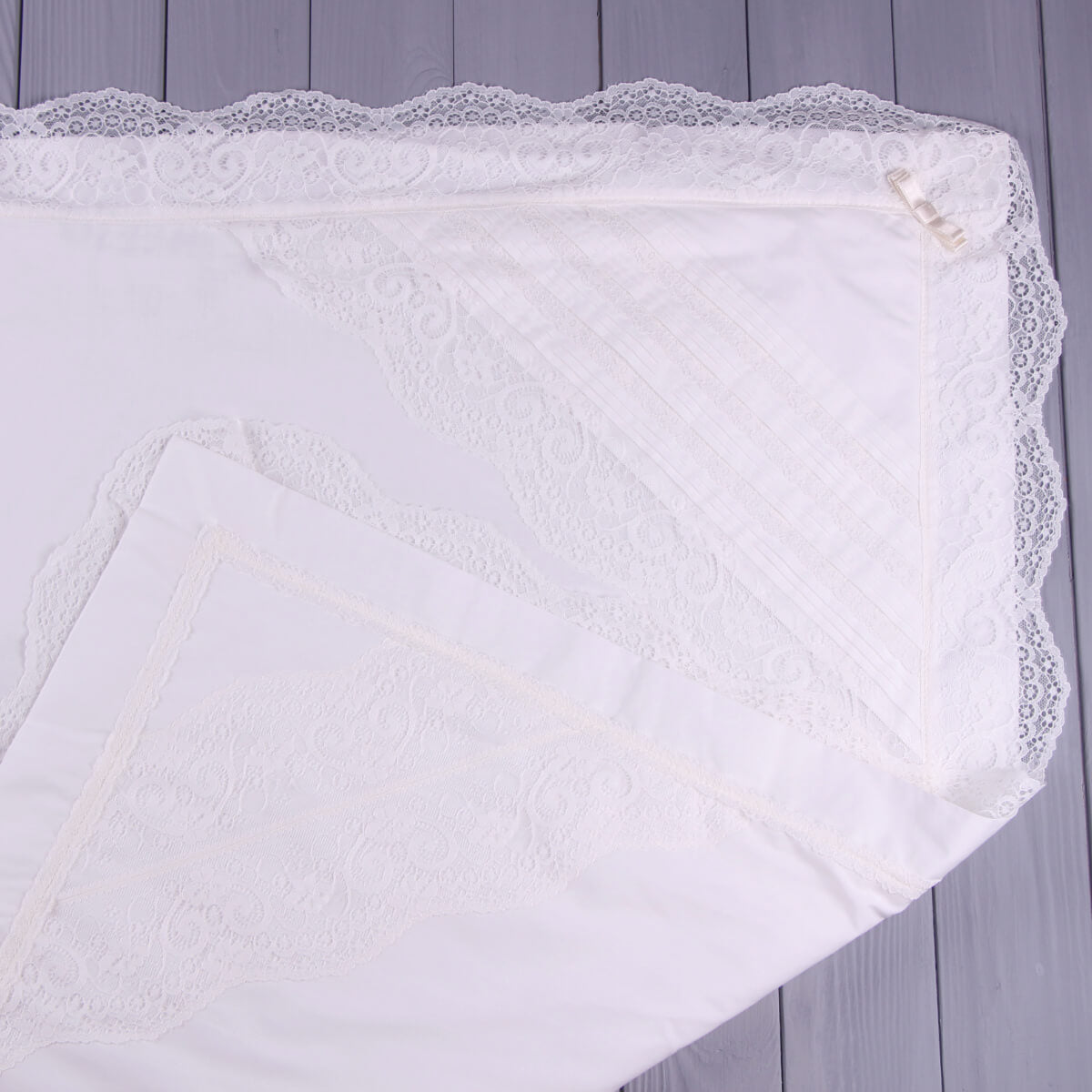 White lace-trimmed Christening Blanket  on a wooden surface