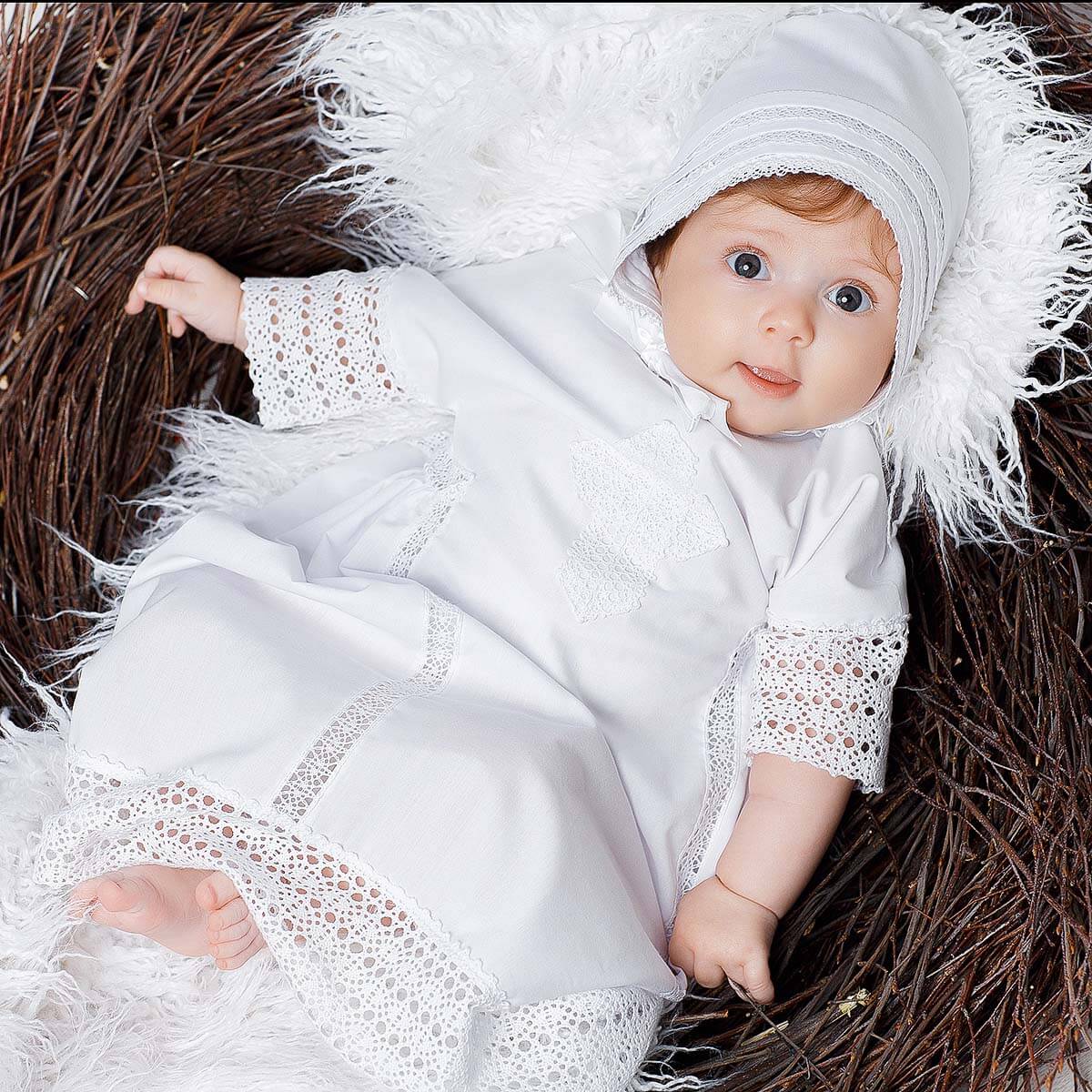 Baby in a Baptism Gown with lace details lying on a textured surface