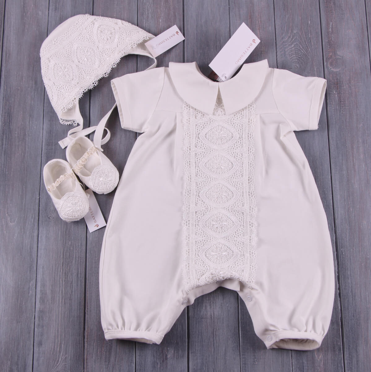 Handmade Baptism Outfit with lace details, white bonnet, and shoes on a wooden surface