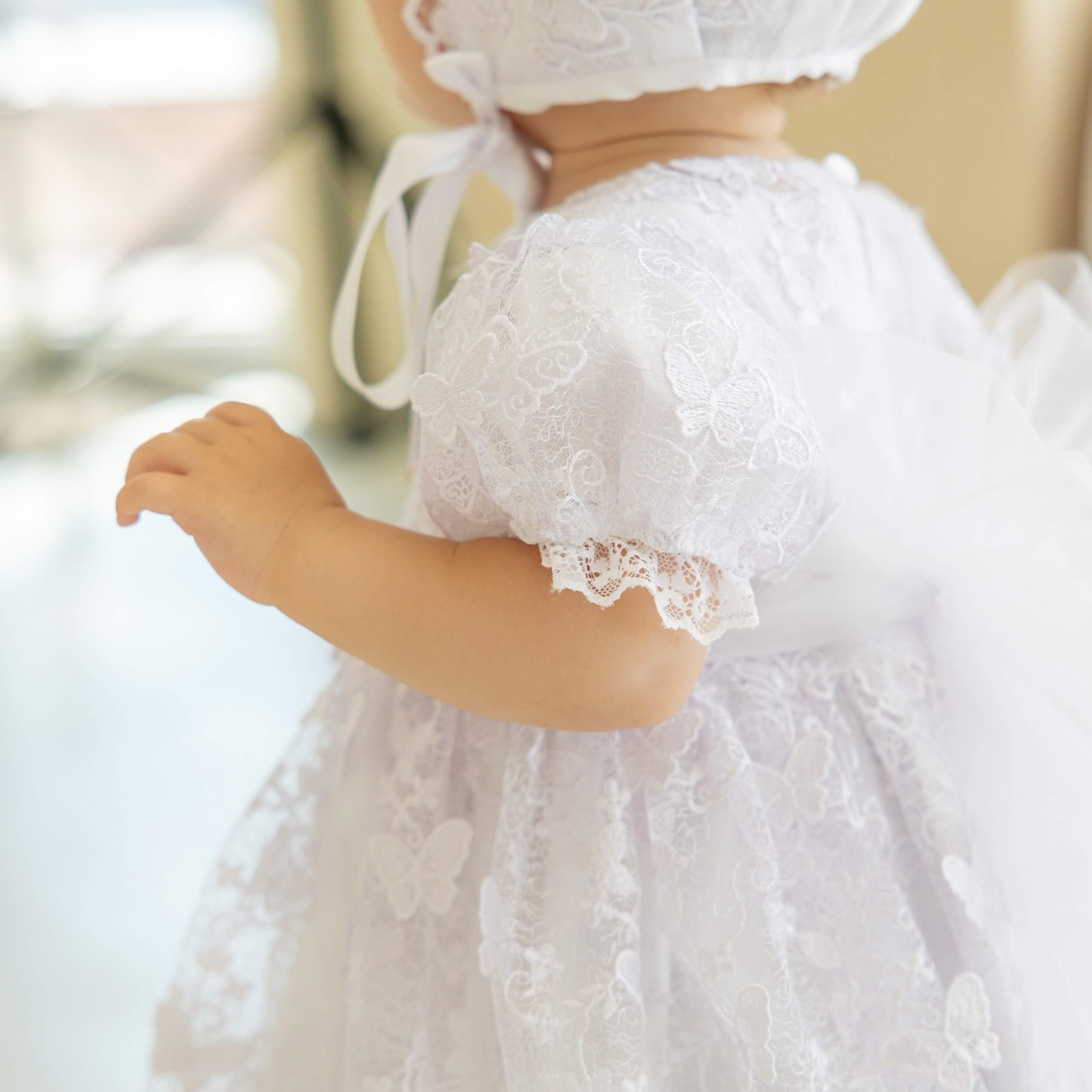 Child wearing a Baptism Dress with Lace with a blurred background