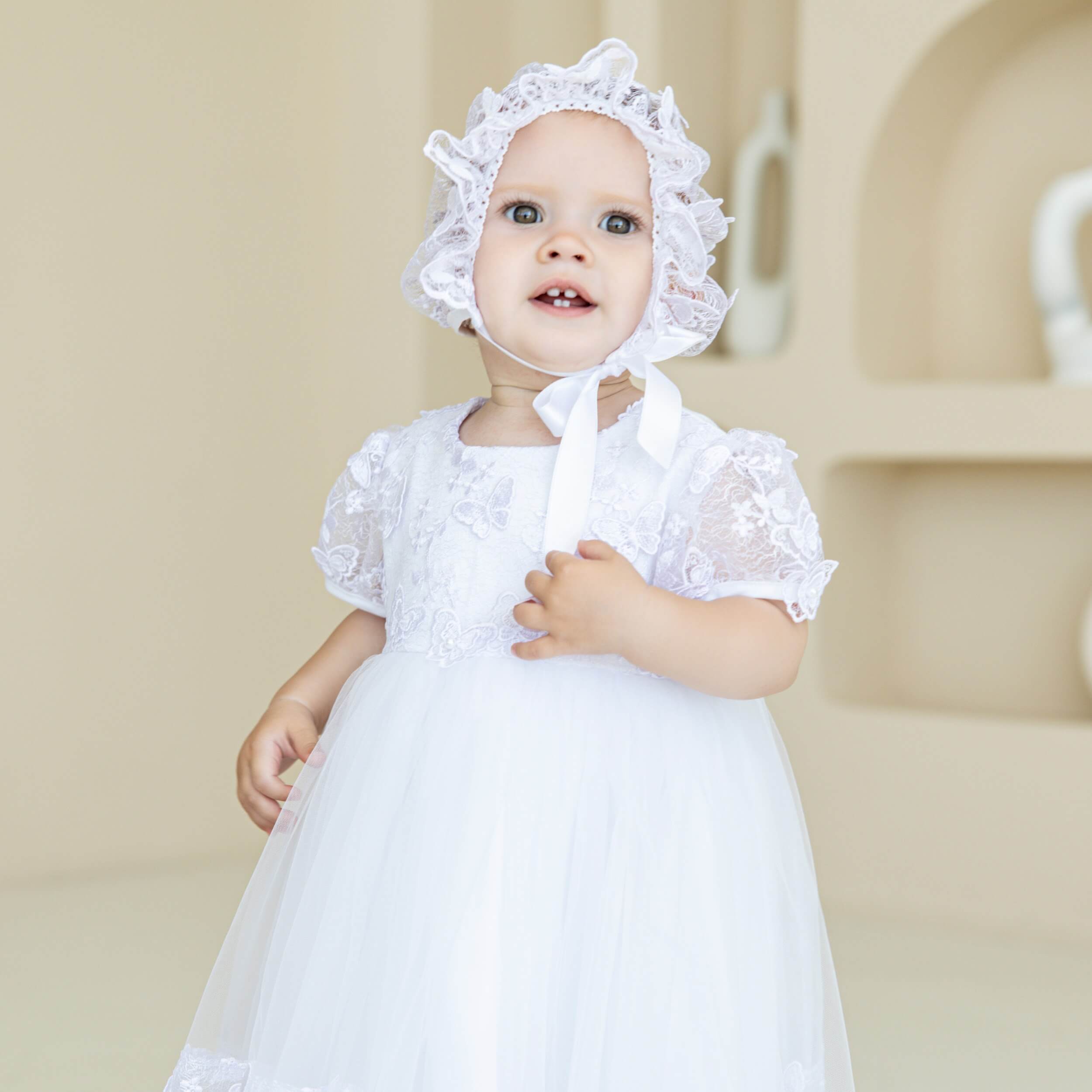 Baptism Dress with Butterfly Lace details and bonnet against a neutral background